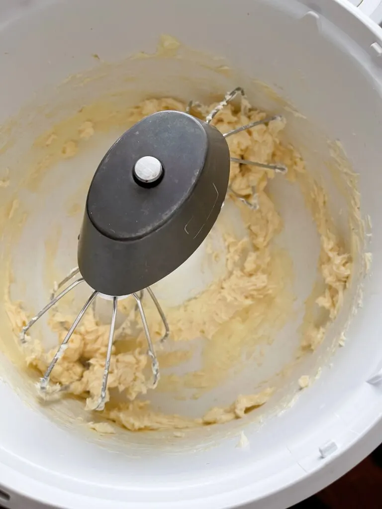 Vanilla extract mixed with butter in a stand mixer bowl.