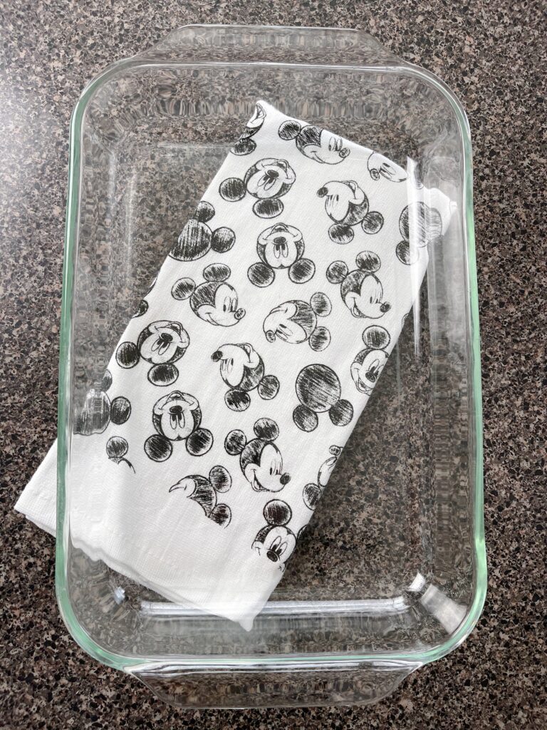 A 9x13 glass baking dish on a Mickey Mouse towel.