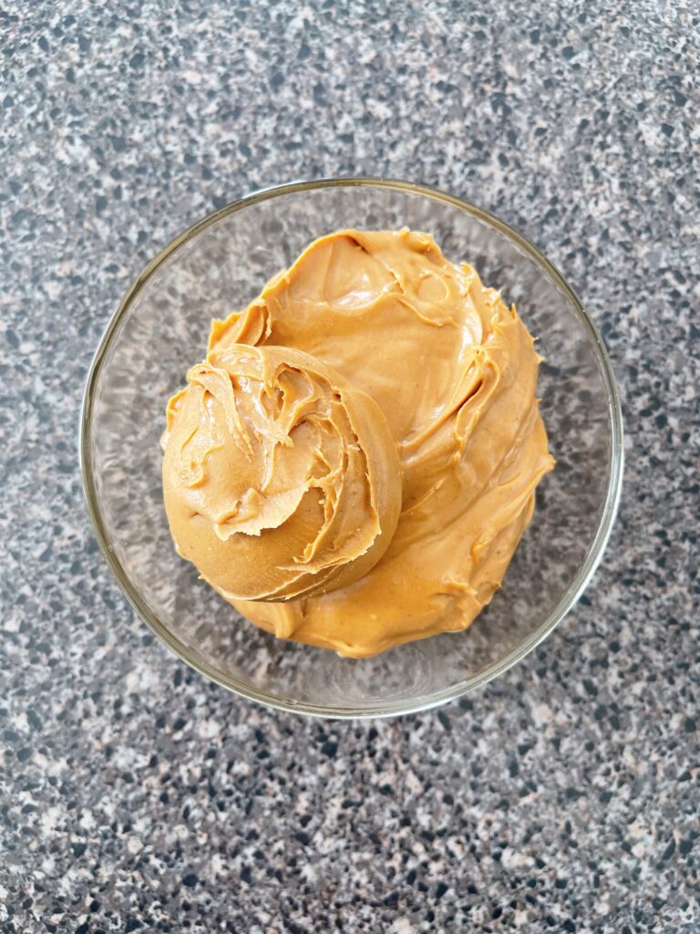 A bowl of creamy peanut butter.