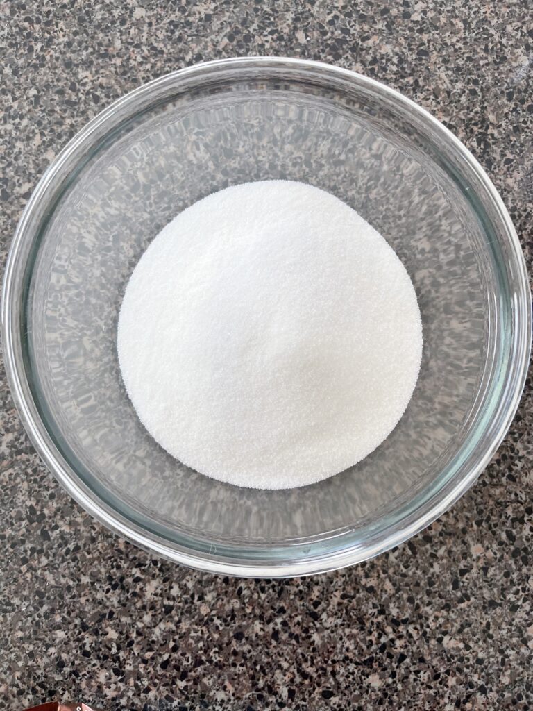 A bowl of granulated white sugar.