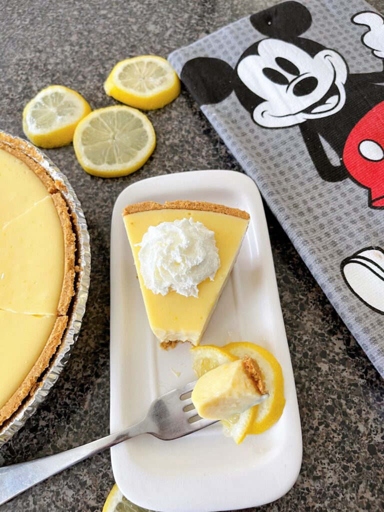Lemon ice box pie with whipped cream and a Mickey Mouse towel.