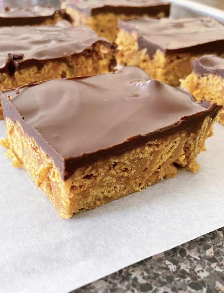 No bake chocolate peanut butter Chex bars on parchment paper.