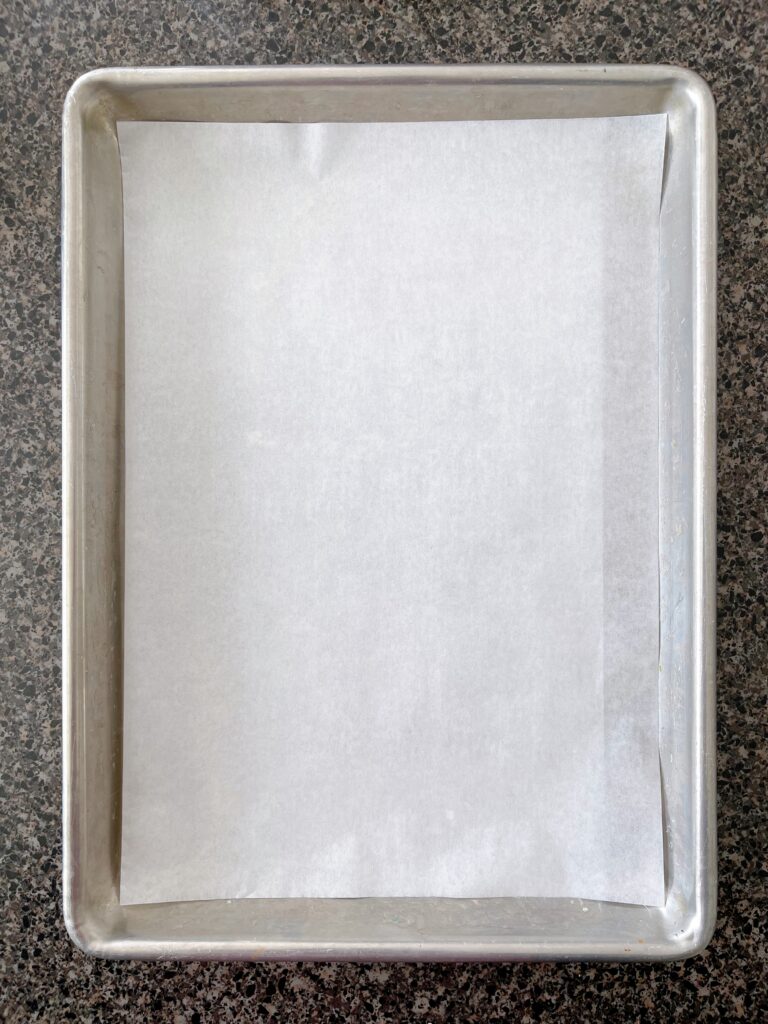 A jelly roll pan with parchment paper.