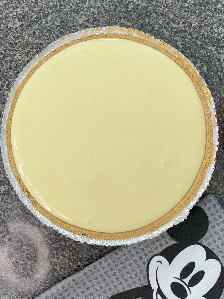 Unbaked Lemon Icebox Pie filling in a graham cracker crust.