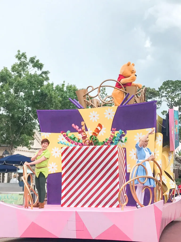 Peter Pan, Winnie the Pooh and Alice in Wonderland on a float in a parade at Magic Kingdom.