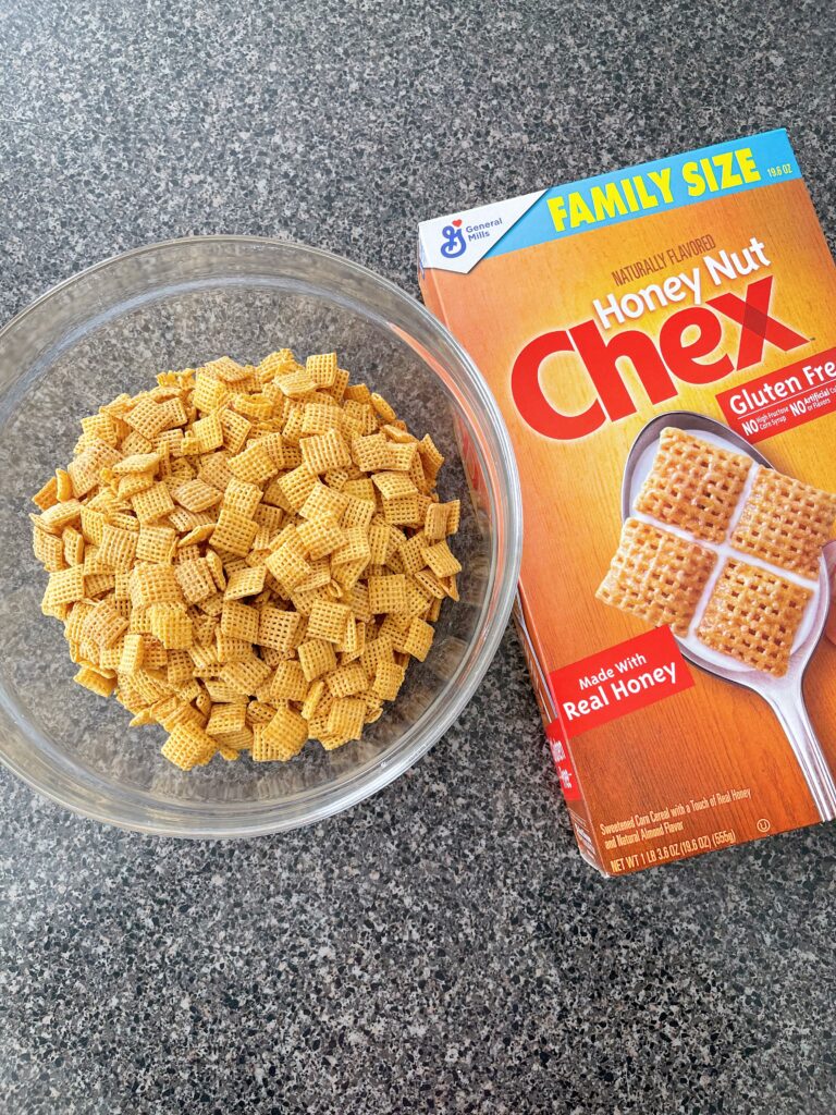A bowl of Honey Nut Chex next to the cereal box.