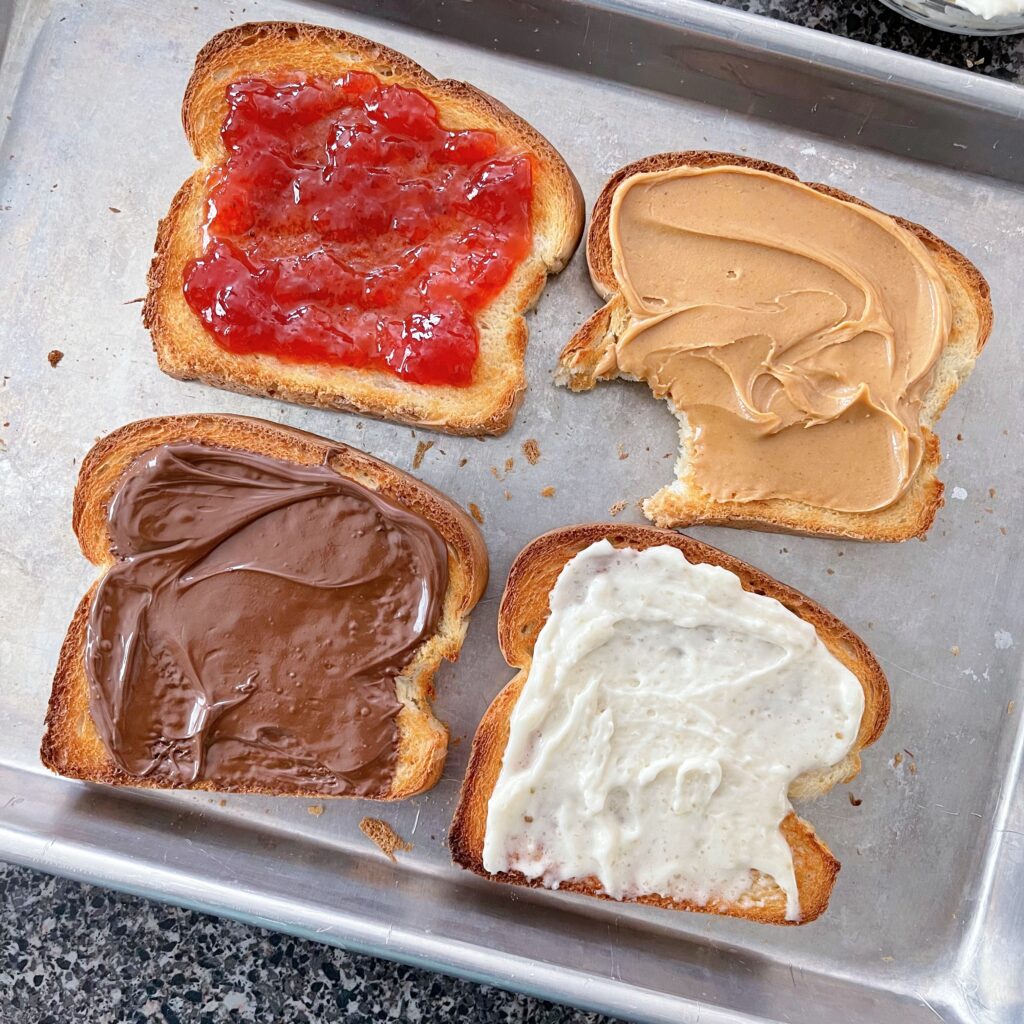 Four slices of toast made in the oven with different toppings.