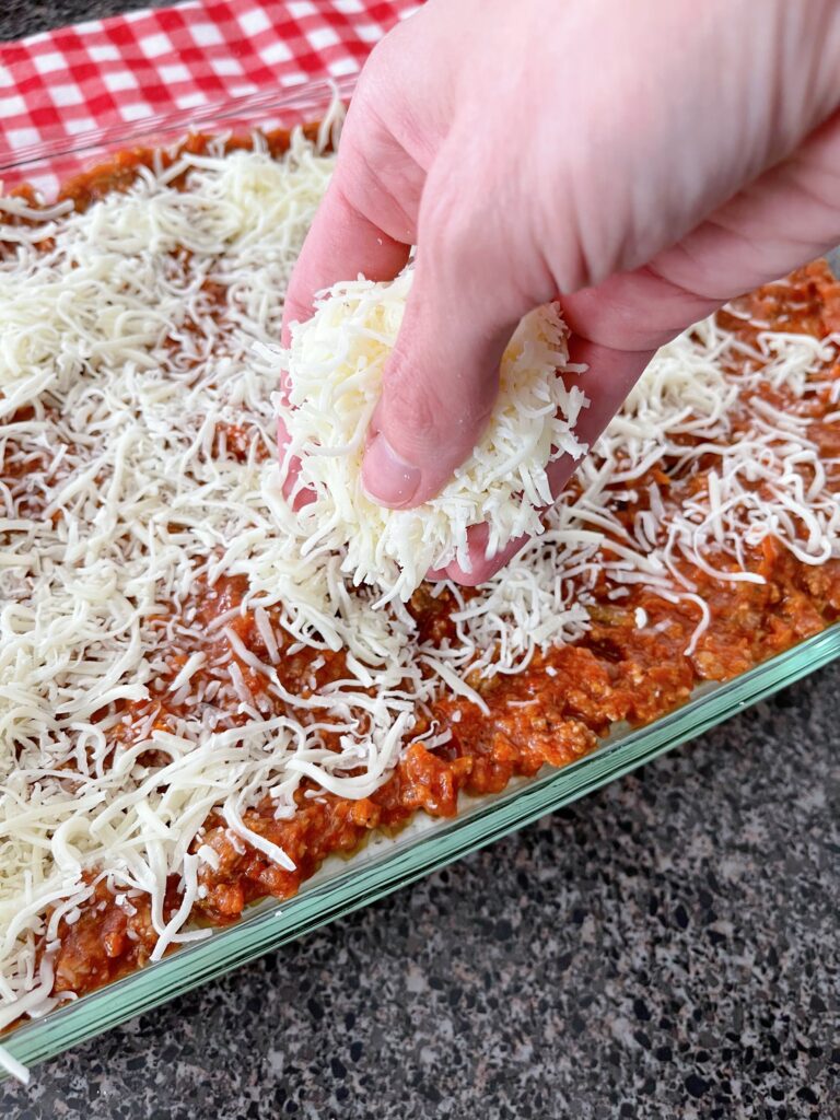 Mozzarella sprinkled over a pan of lasagna.