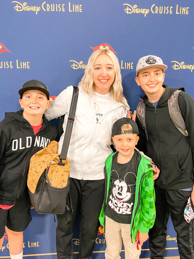 A mom and three kids getting on a Disney Cruise.