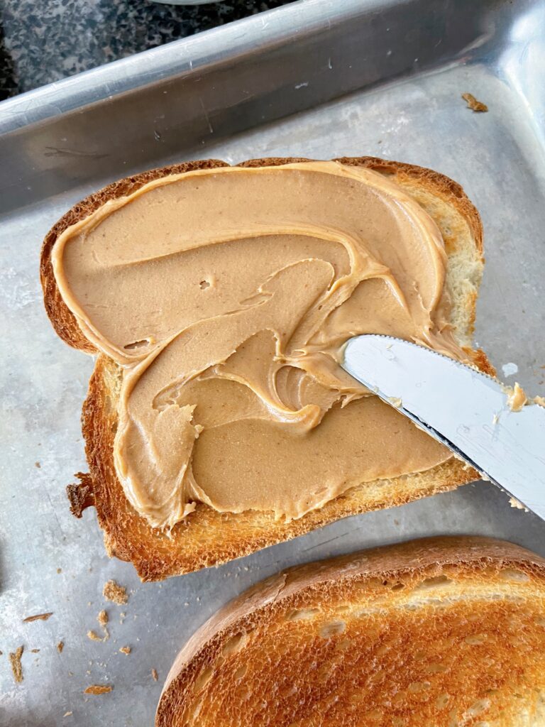Peanut butter spread on oven toast.
