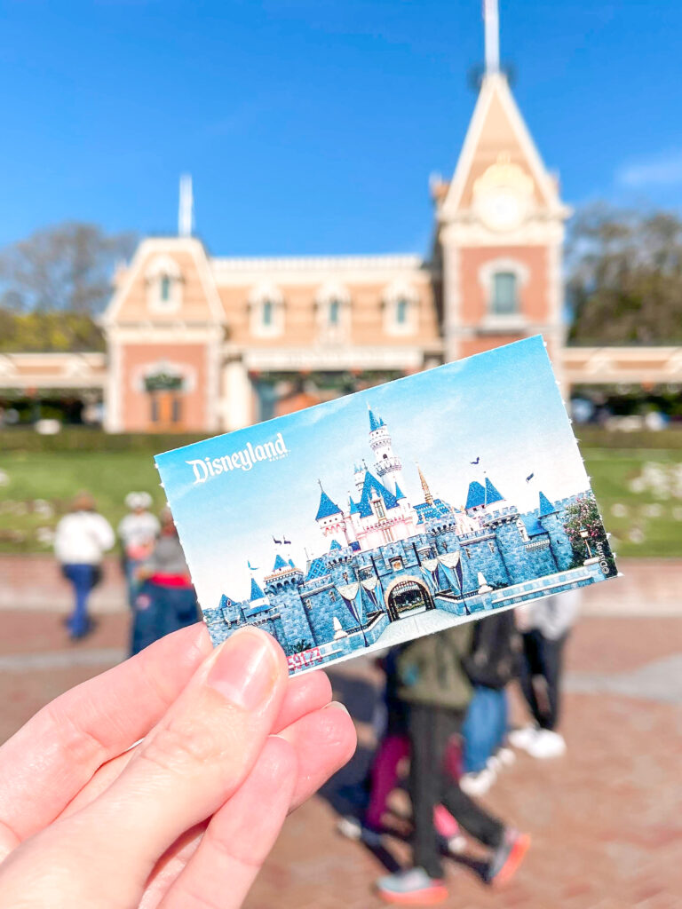 A Disneyland ticket in front of the Disneyland Train Station.