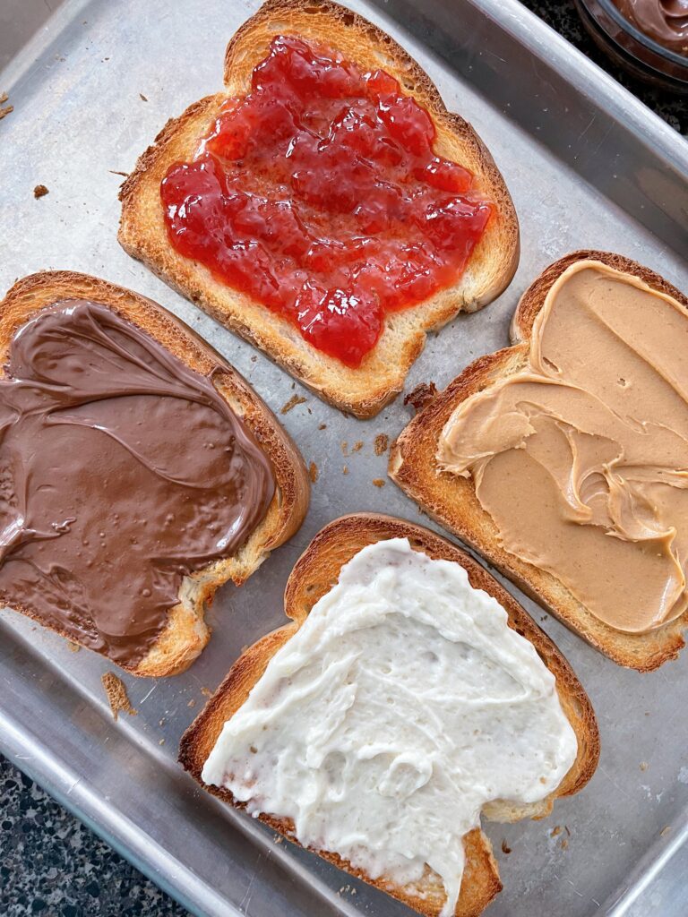 Four slices of toast made in the oven with different toppings.