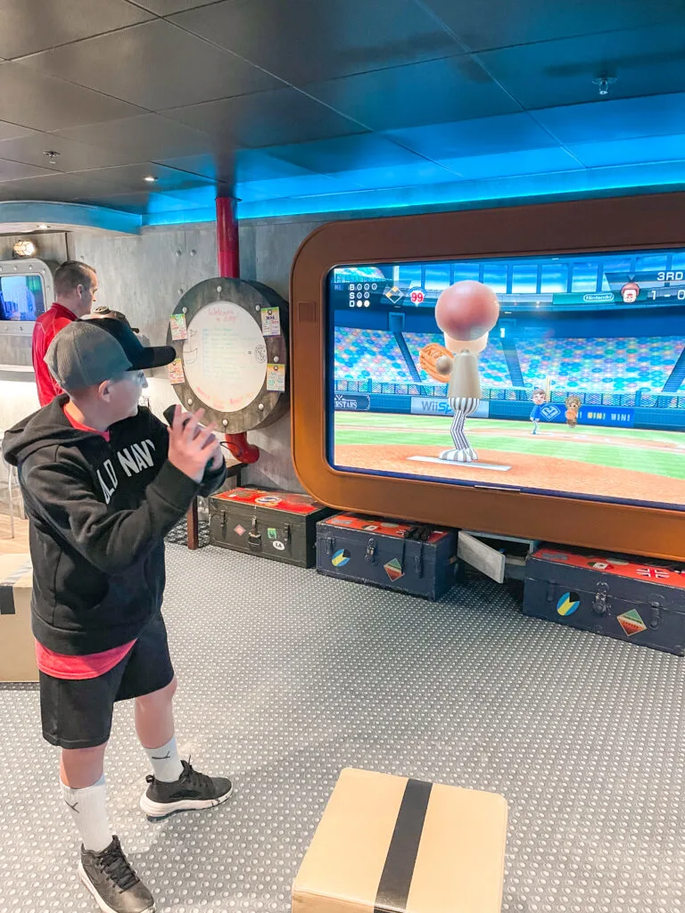 A boy playing a video game in the Edge on the Disney Wonder.