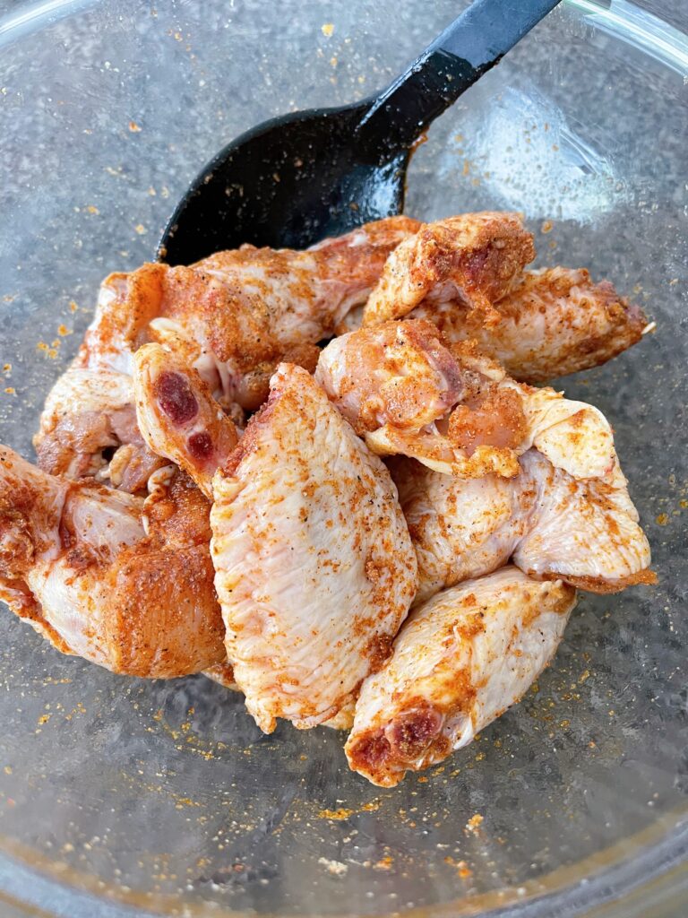 Chicken wings with spices in a bowl.