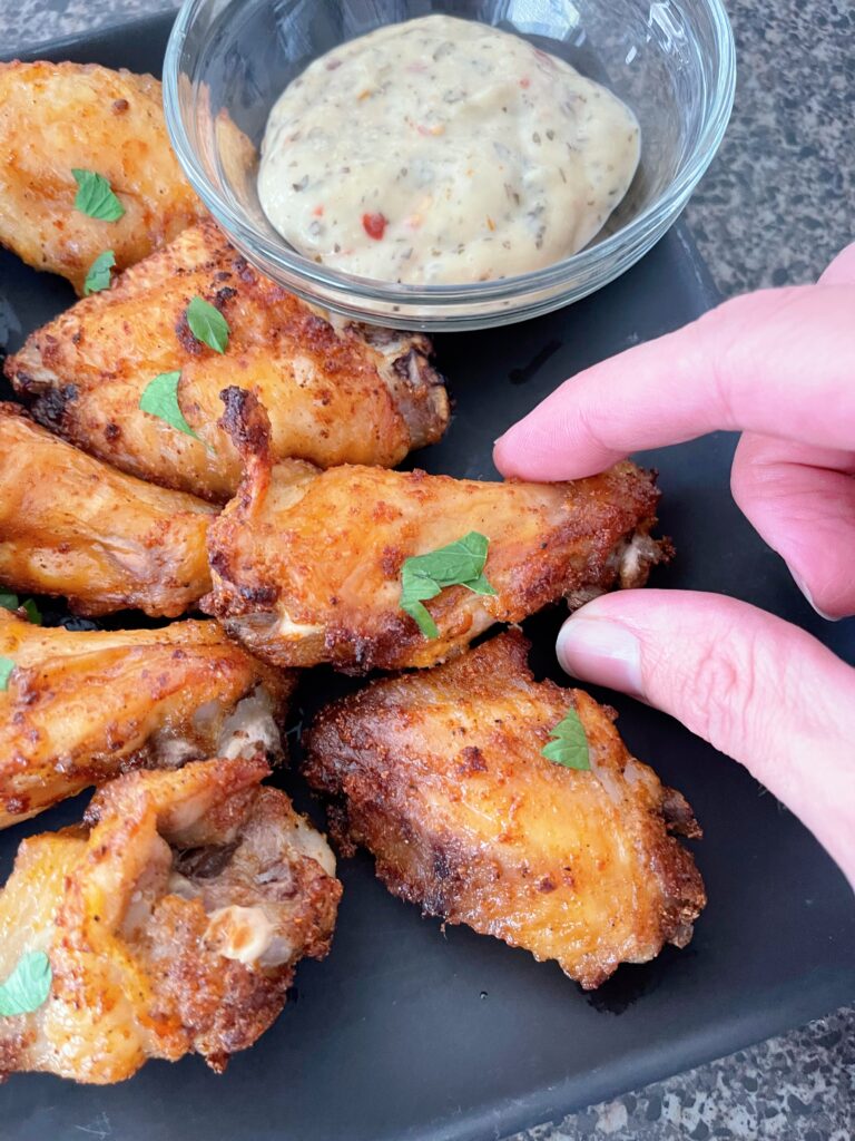Air fryer chicken wings on a black plate.