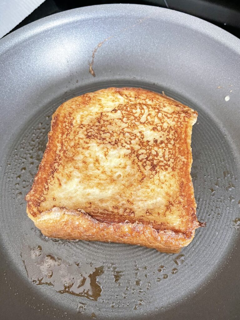 French toast cooking in a frying pan.