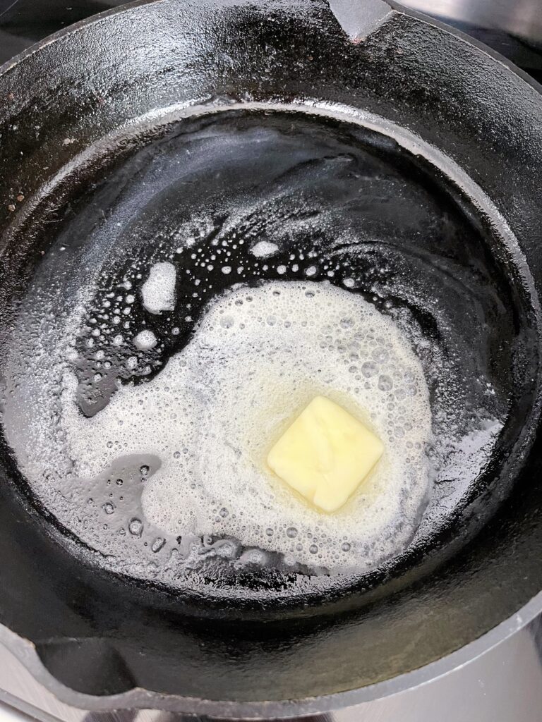 Butter melting in a cast iron skillet.