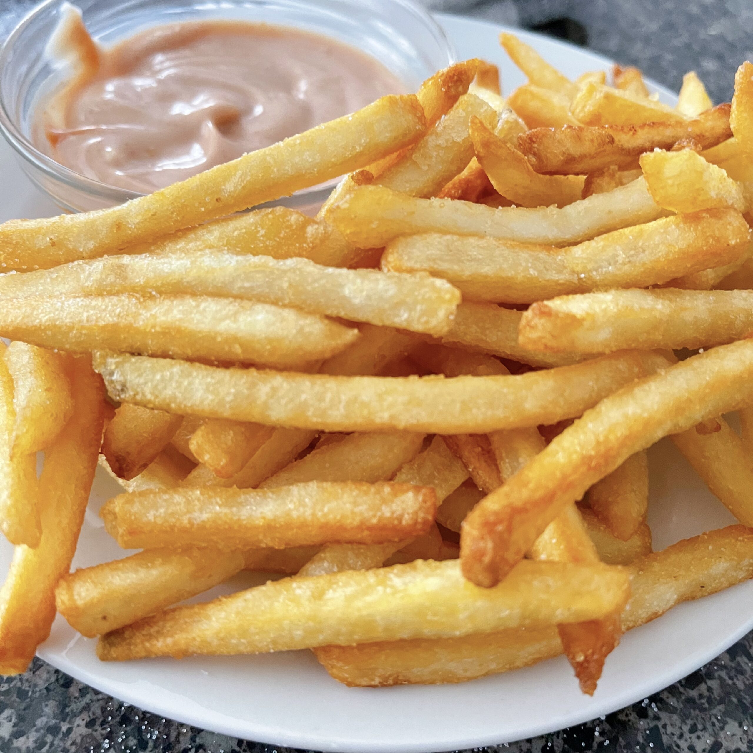 Air fryer french fries on a plate with fry sauce.