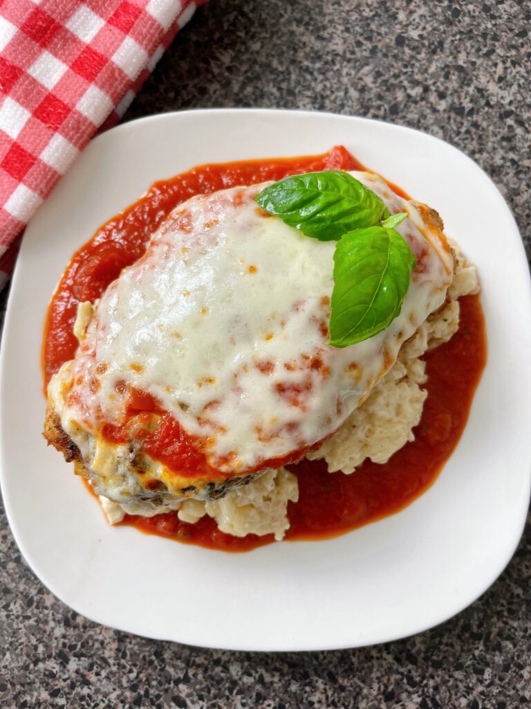 Chicken parmesan on a white plate.