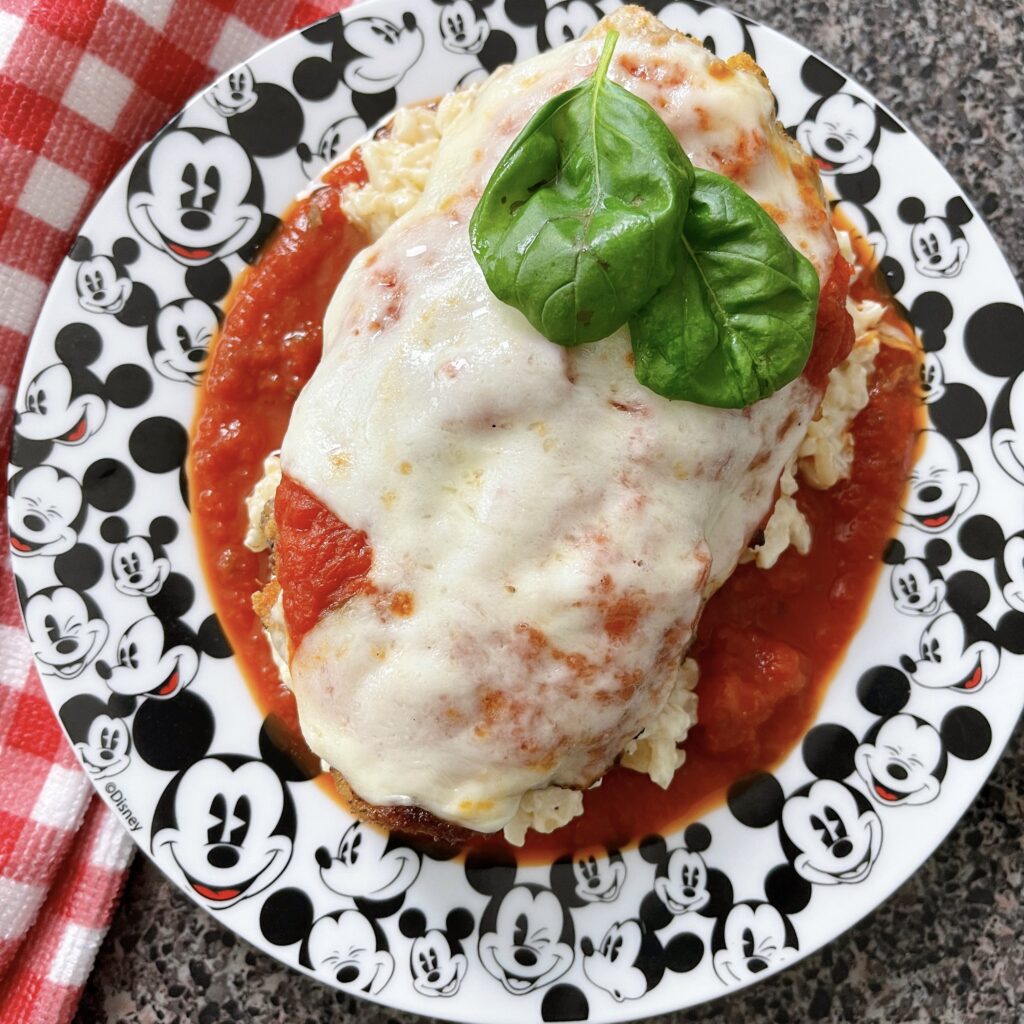 Crispy chicken parmesan with risotto on a Mickey Mouse plate.