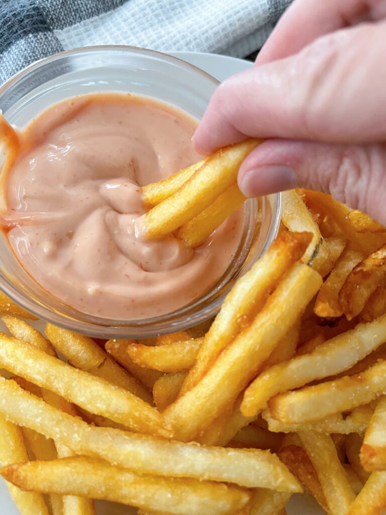 Air fryer french fries on a plate with fry sauce.
