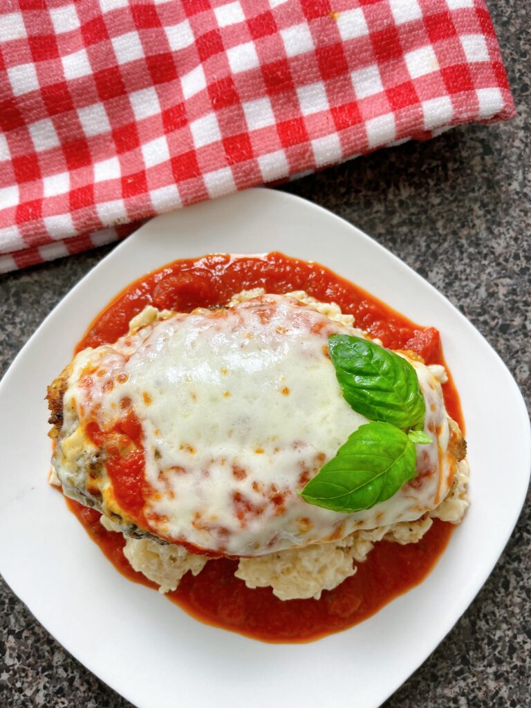 Chicken parmesan on a white plate.