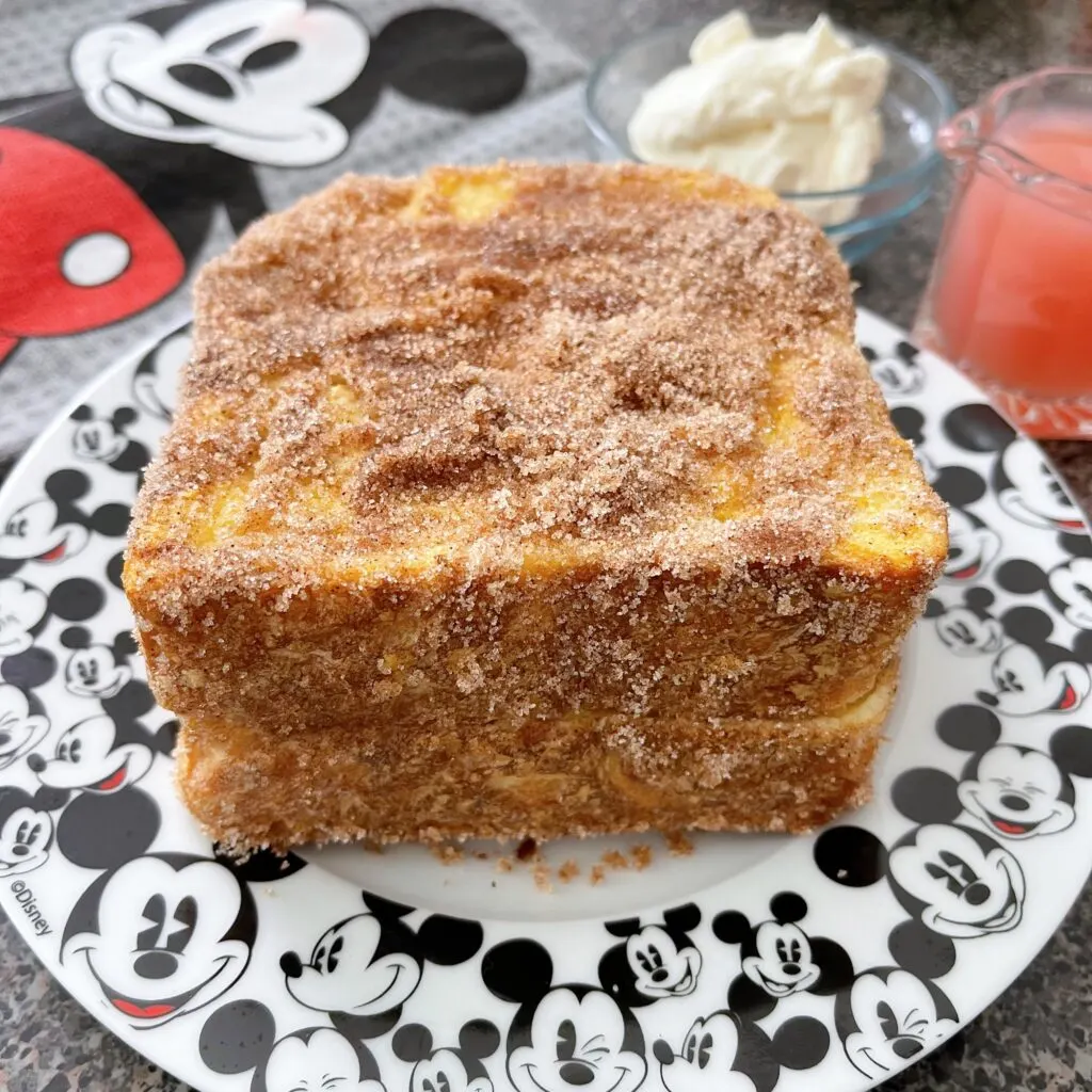 Cinnamon coated French Toast on a Mickey Mouse plate.
