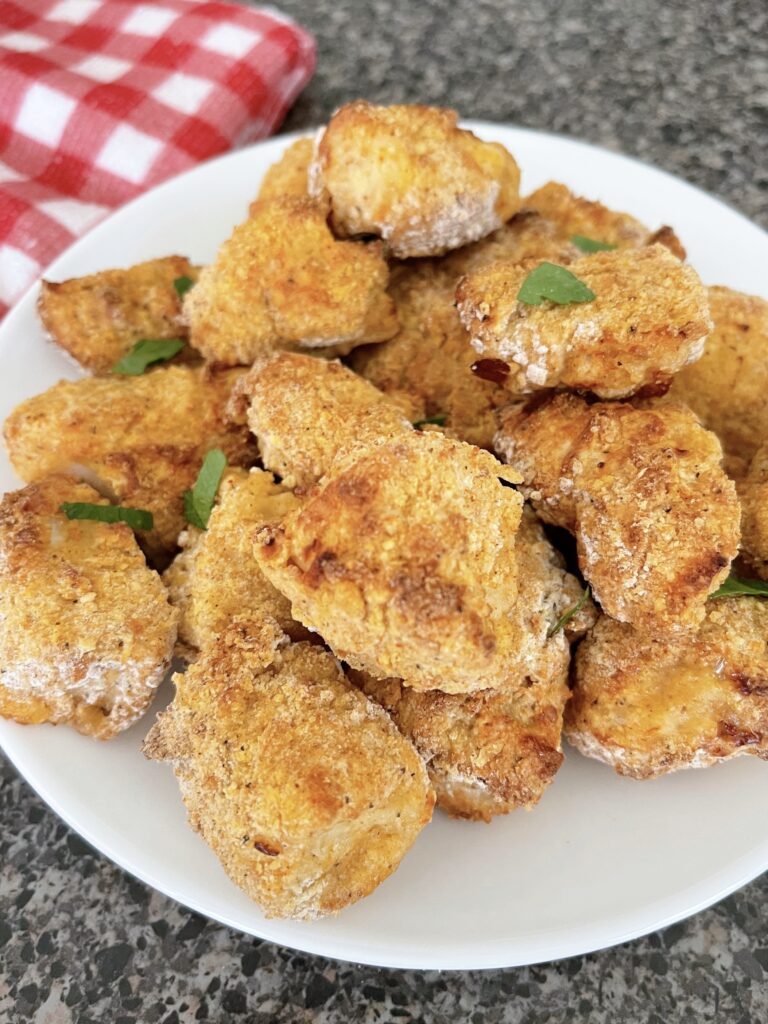 Air fryer chicken nuggets on a white plate.