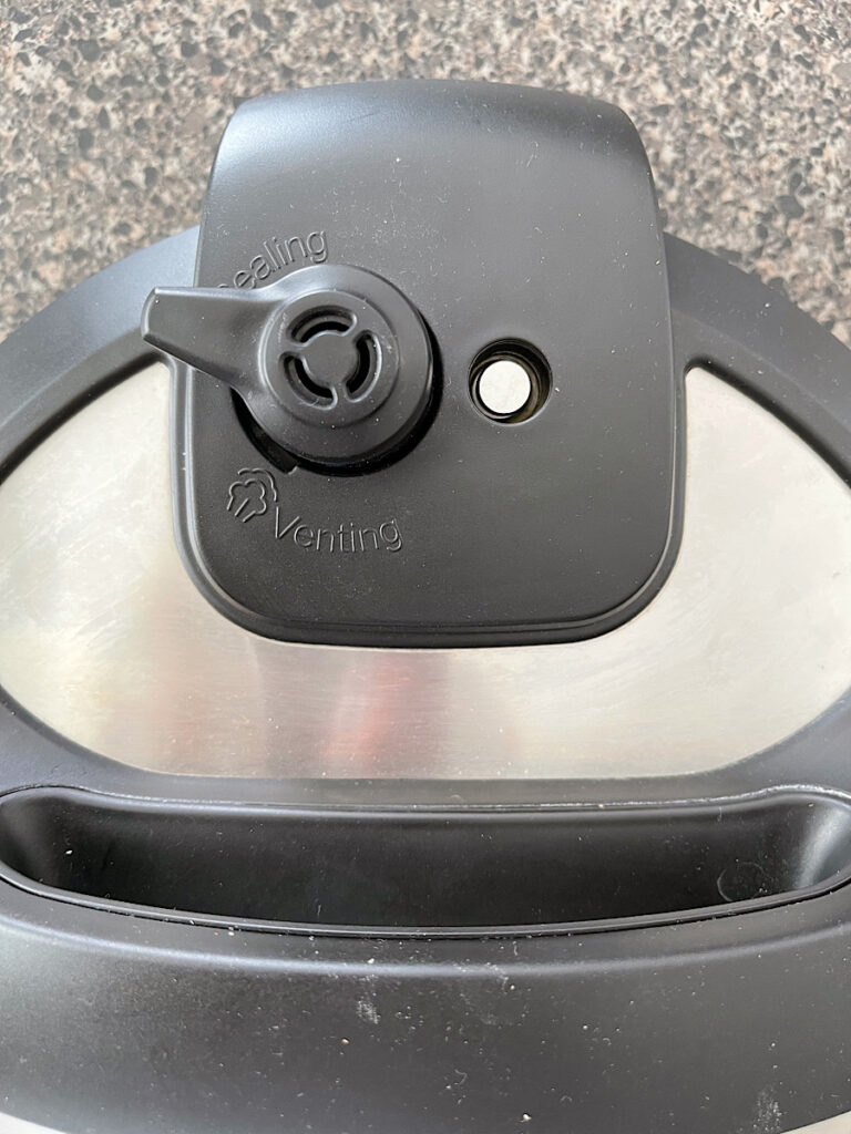 The lever on an instant pot lid set to seal.