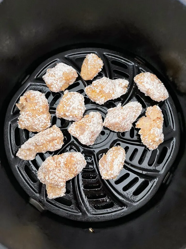 Chicken nuggets in an air fryer basket.