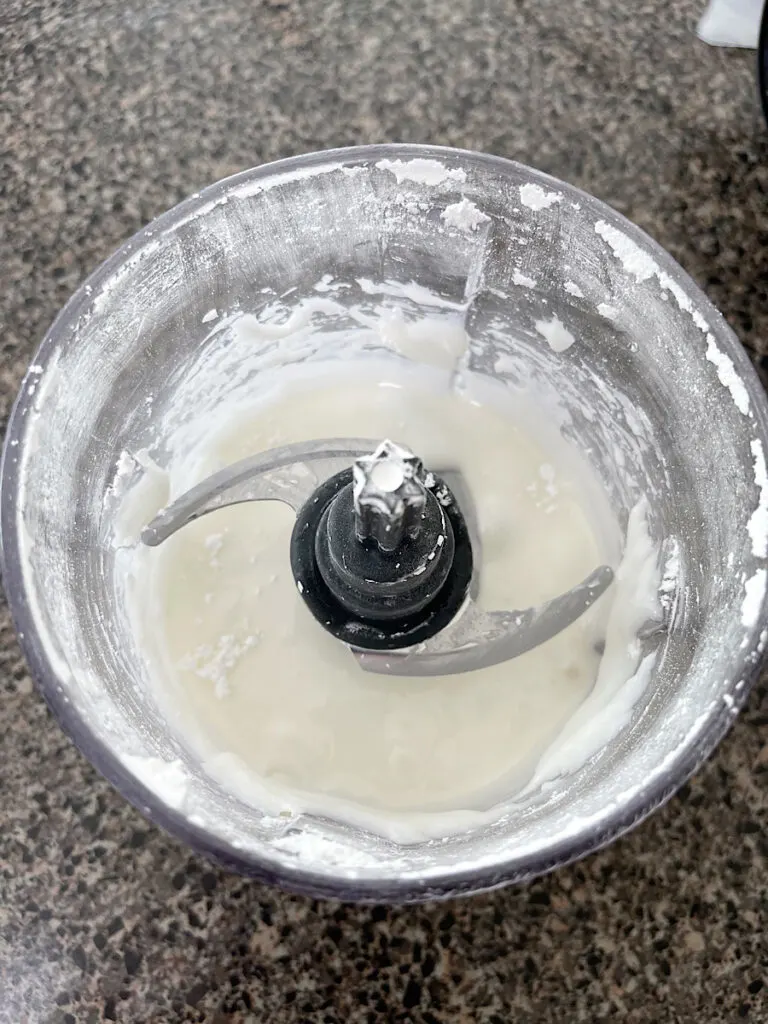 Milk and powdered sugar in a food processor.