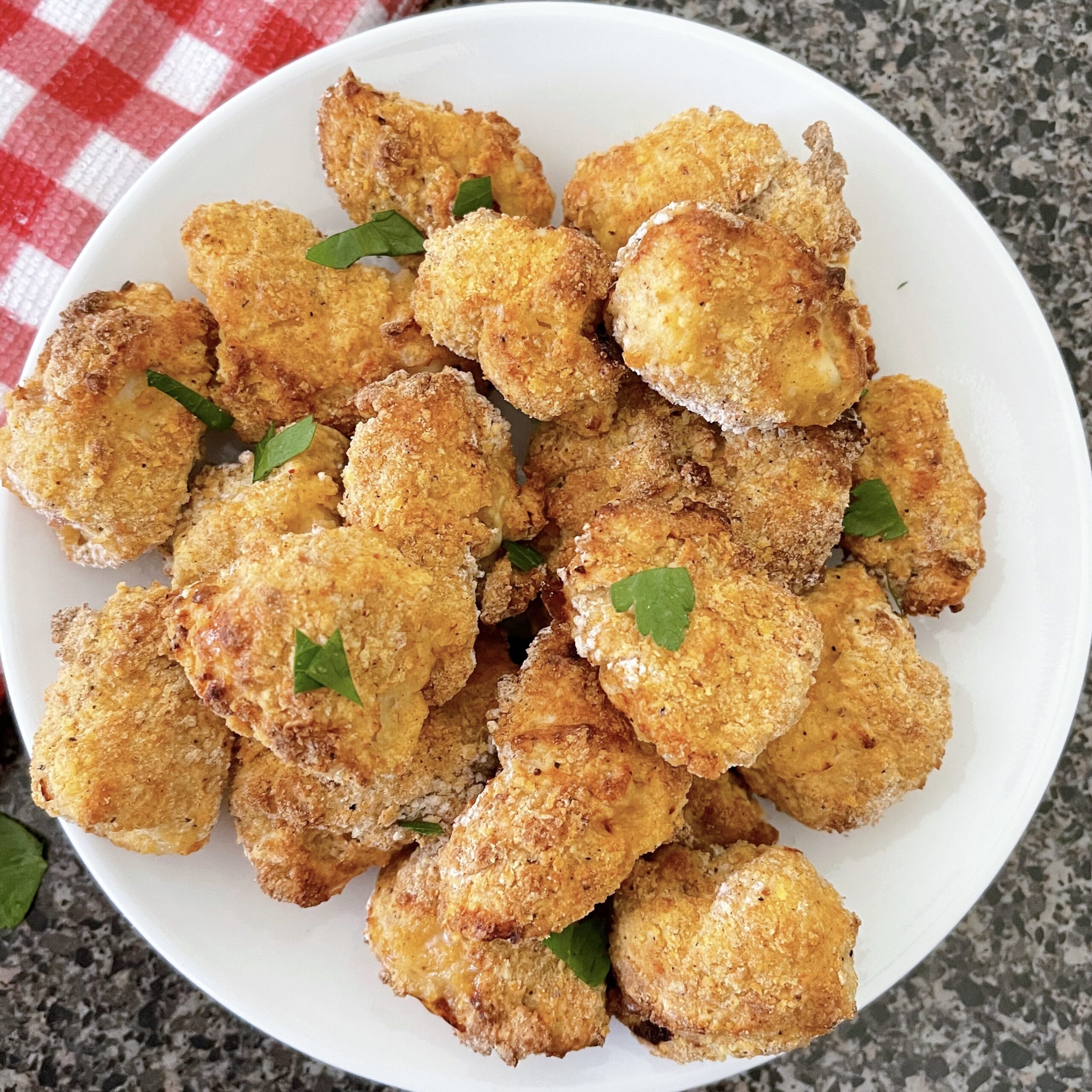 Air fryer chicken nuggets on a white plate.