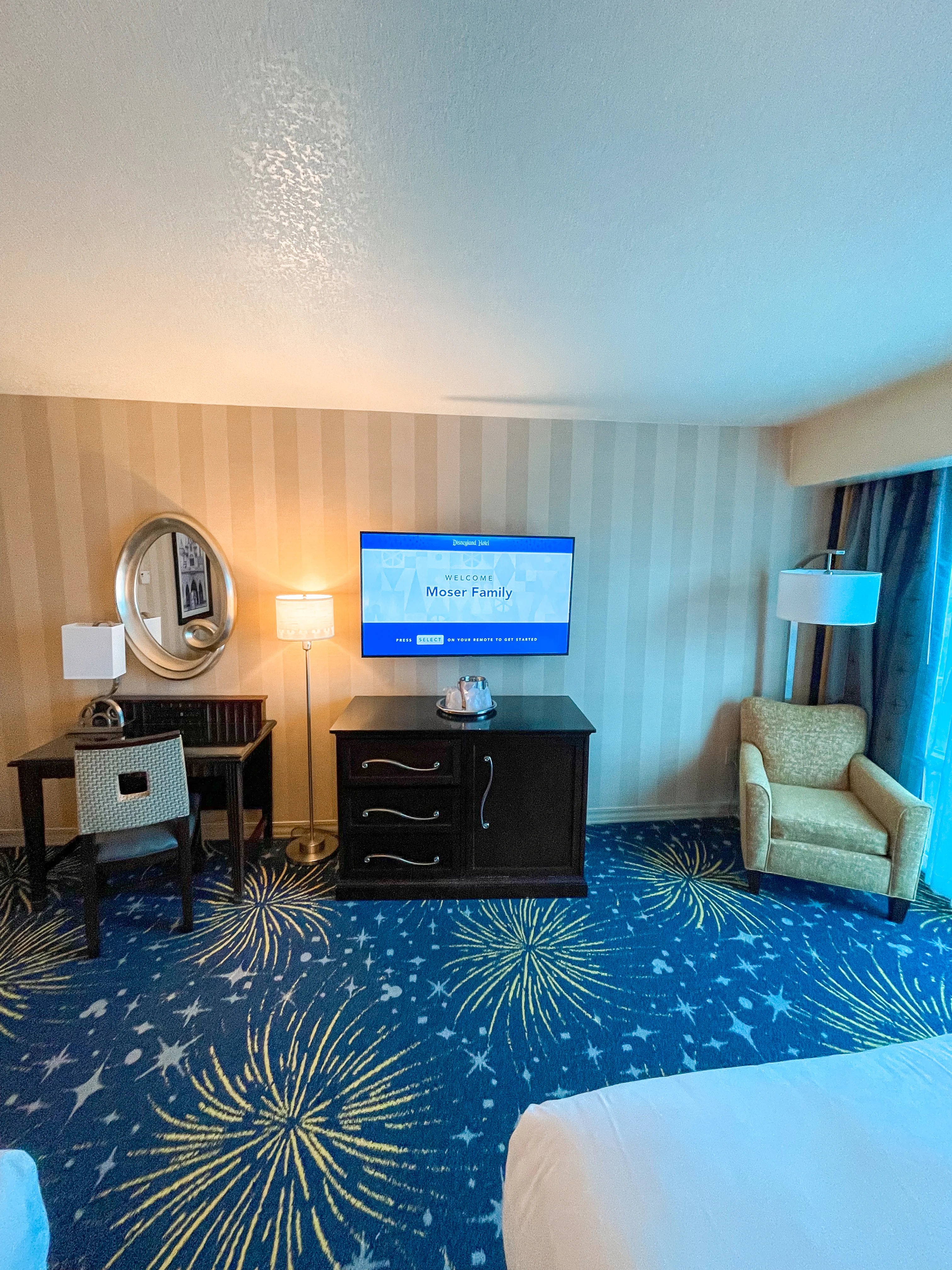 Vanity, TV, mini fridge, and chair in a room at the Disneyland Hotel.