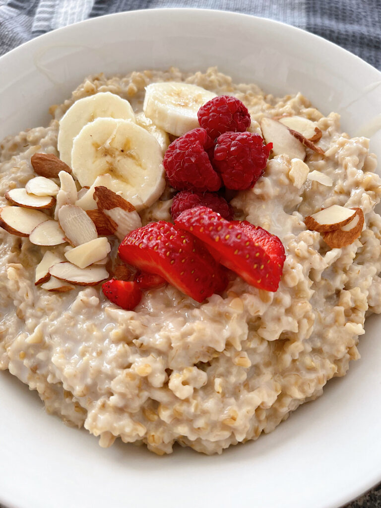 A bowl of overnight instant pot steel cut oats with fruit and almonds.