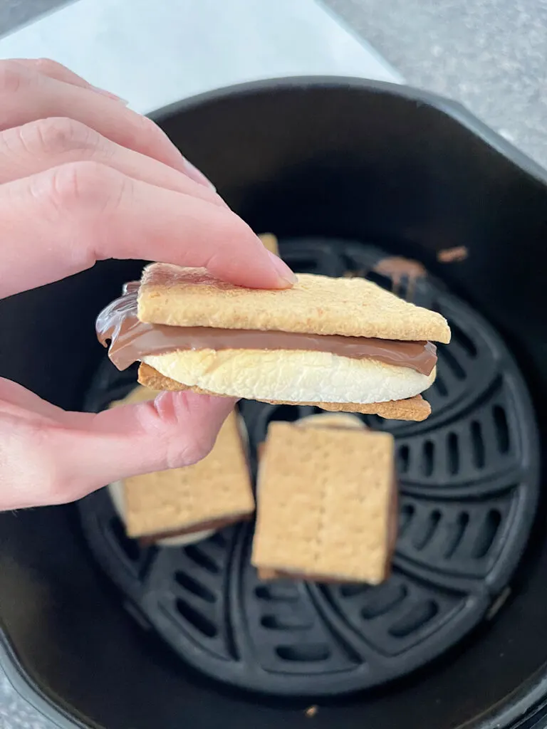 Someone holding a smore cooked in an air fryer.