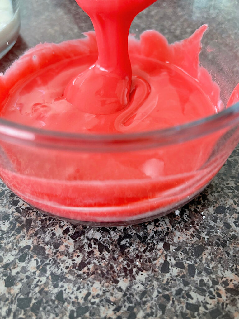 Red sugar cookie icing in a bowl.