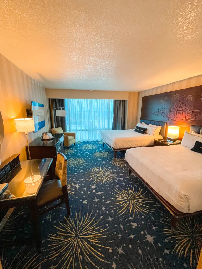 A Disneyland hotel room with two queen beds and a view of the pool.