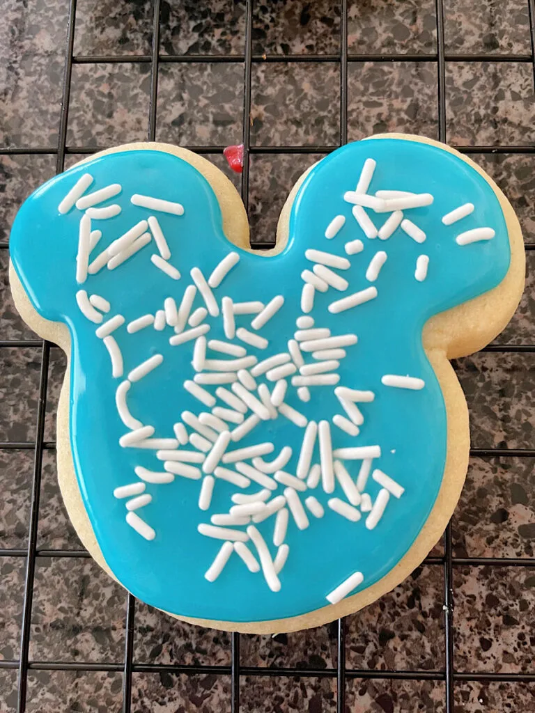 A Mickey Mouse shaped sugar cookie with icing that hardens decorated for Christmas.