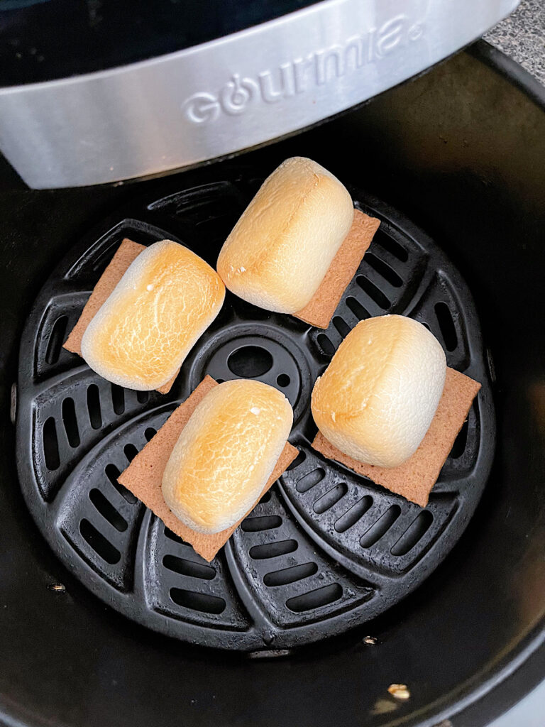 Toasted marshmallows on graham crackers in an air fryer.