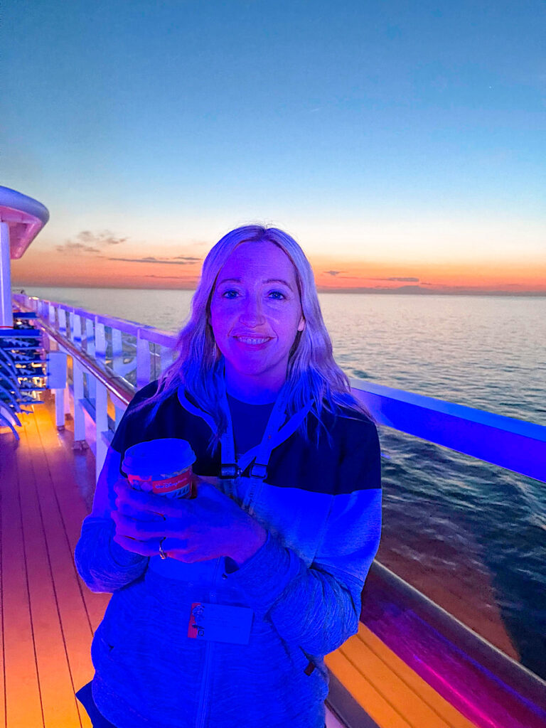A lady on the top deck of the Disney Magic in the Mediterranean at sunset.