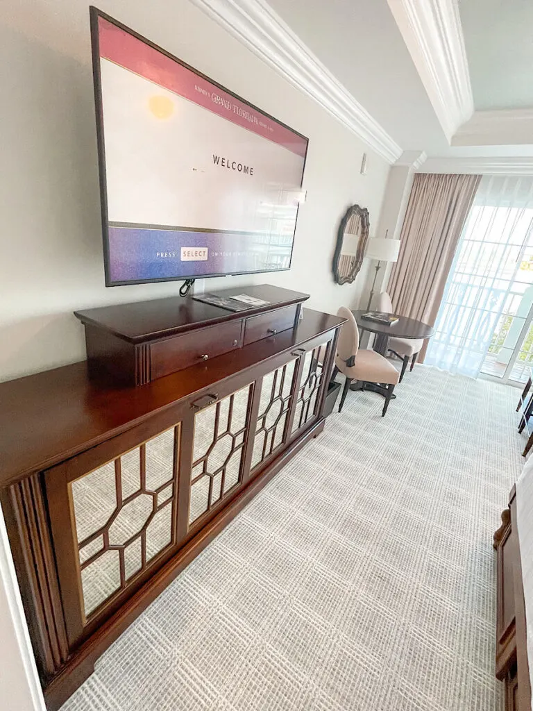 Grand Floridian deluxe studio villa room with a large tv and a table with chairs.