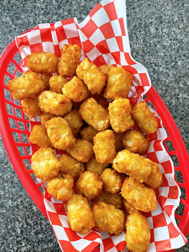 Air Fryer tater tots in a red basket.