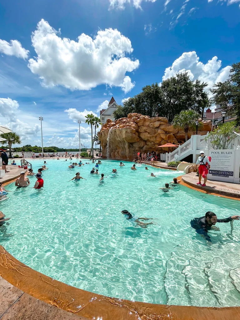 Swimming pool with a waterfall and water slide near the villas building at Grand Floridian.