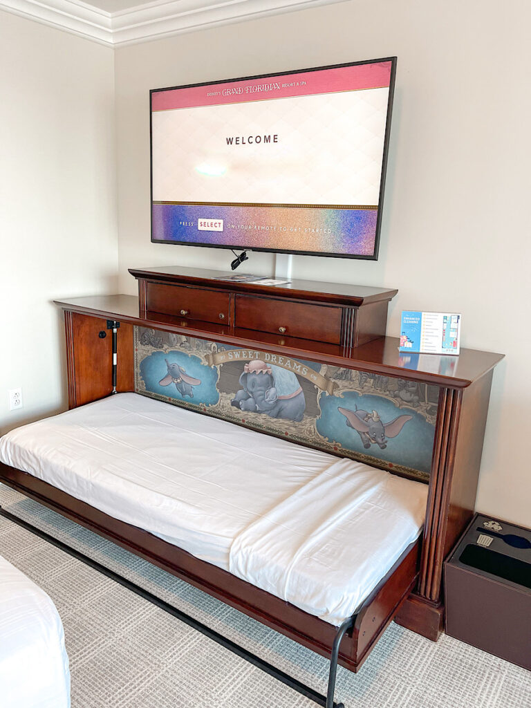 A fold down bed under the tv in a Grand Floridian Hotel Room.