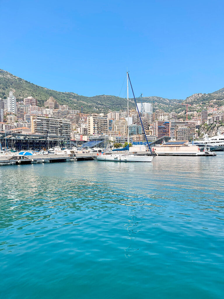 Boats in a marina with bright blue water in Monaco.