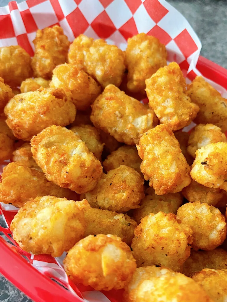 Air Fryer tater tots in a red basket.