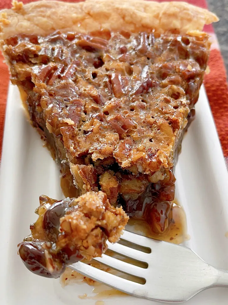 Chocolate pecan pie on a plate with a fork.