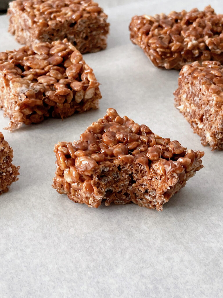 A chocolate rice crispy missing a bite.