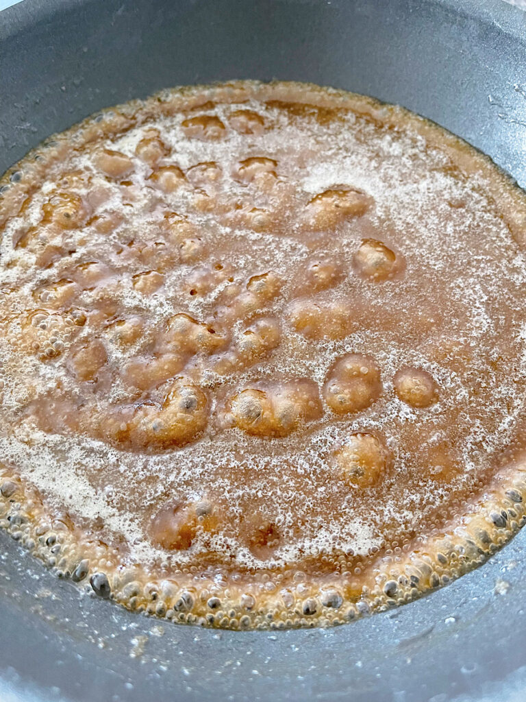 Melted butter and brown sugar boiling in a pan.