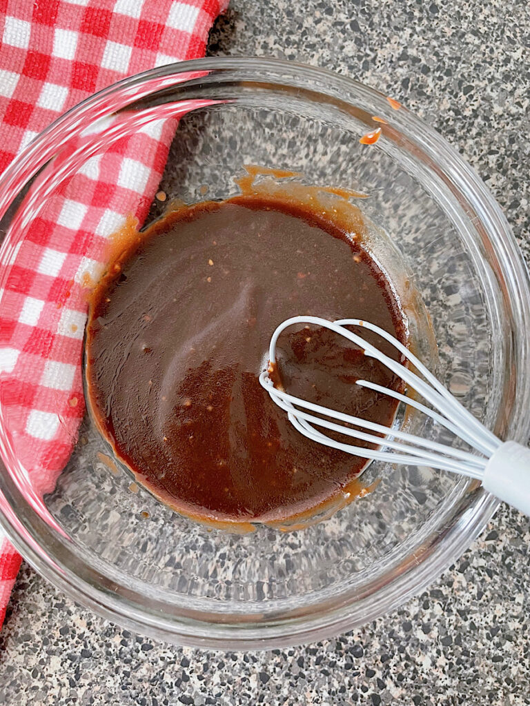 BBQ vinaigrette in a clear bowl with a red and white towel.